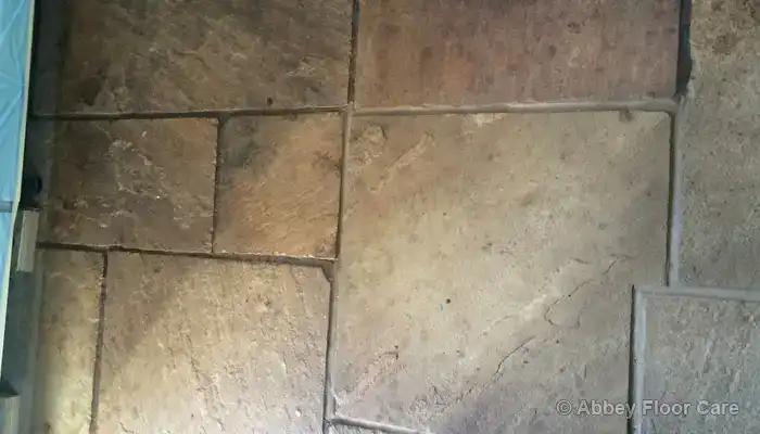Cleaning Indoor Flagstone Floors: Close-up of riven sandstone texture trapping fine dirt in pits and grooves