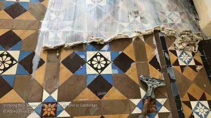Thick sealer being scraped from Victorian tiles to expose original clay surface