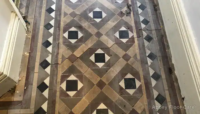 Victorian floor tiles chipped and cracked along old carpet gripper rod edges