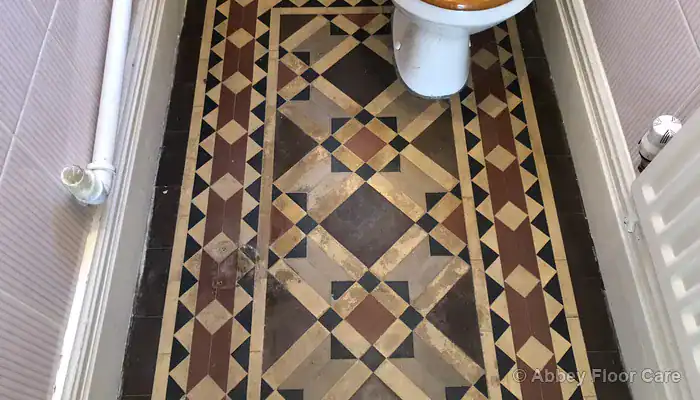 White efflorescence salt deposits forming across unsealed Victorian clay floor tiles