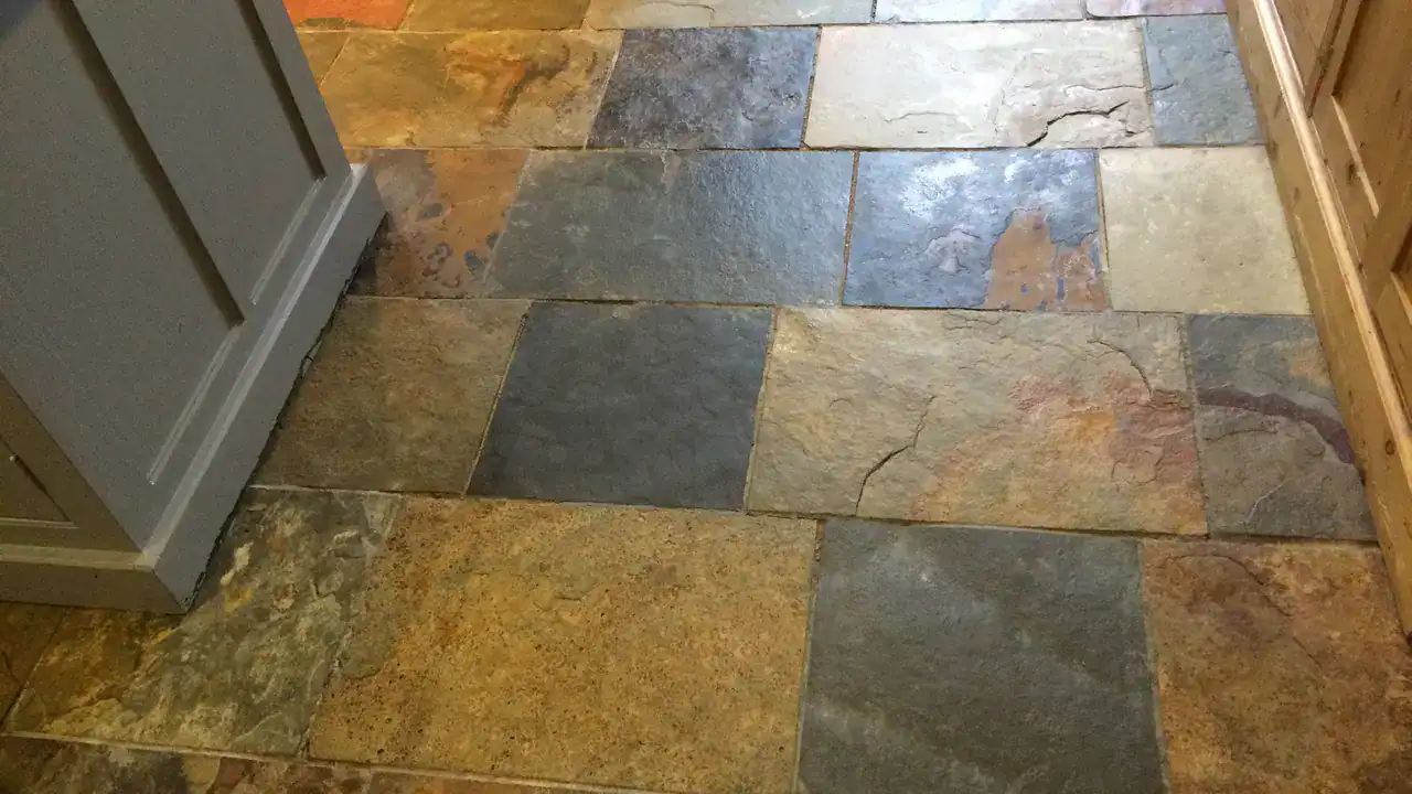 Failed grout joints between uneven slate tiles before repair