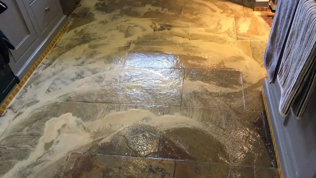 Low speed scrubbing releasing softened wax build-up from a slate floor