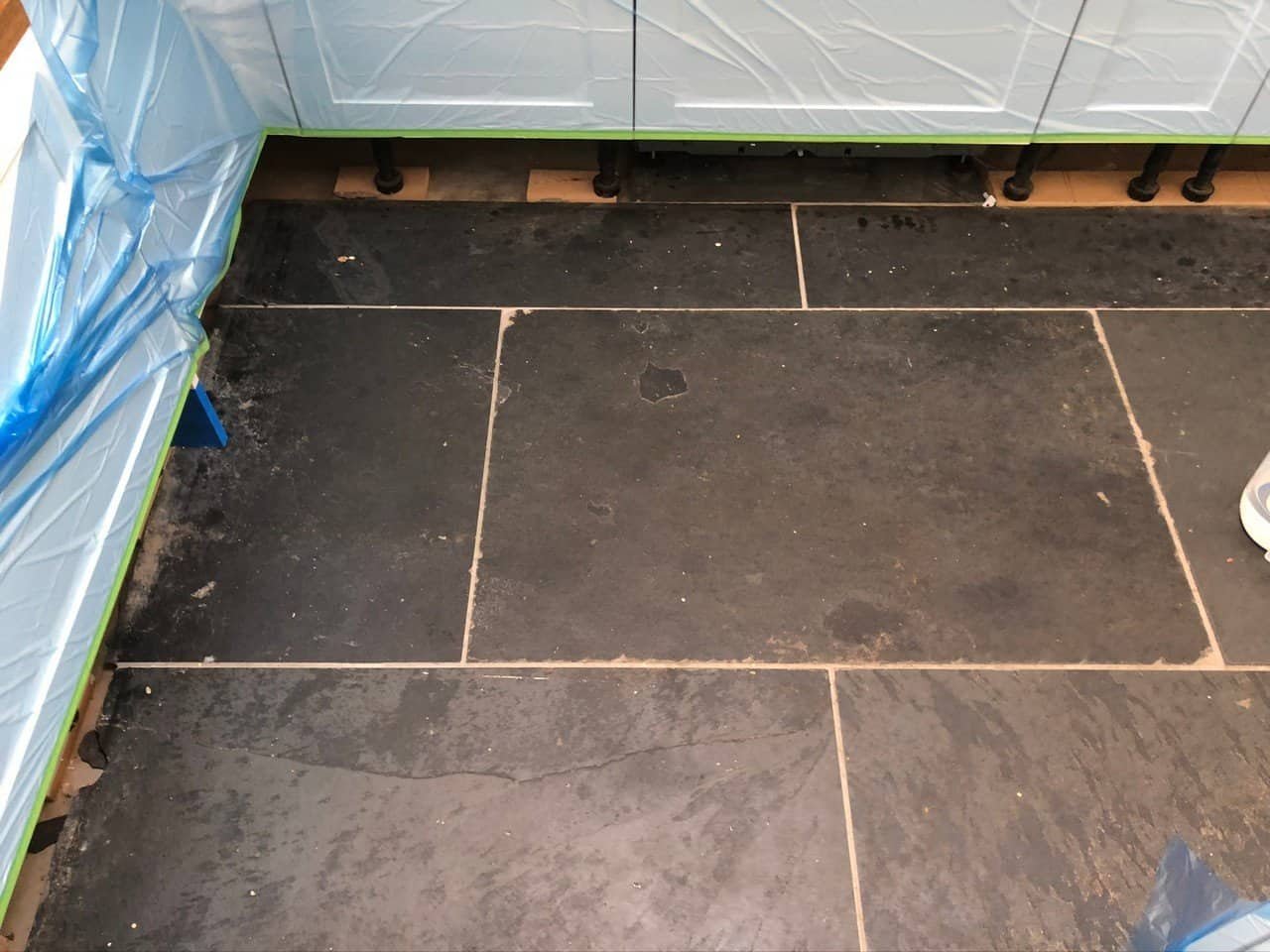 Close view of dull slate tiles with ingrained dirt and uneven finish
