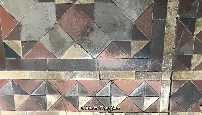 Victorian mosaic tiles with faded colours and a dull worn surface finish