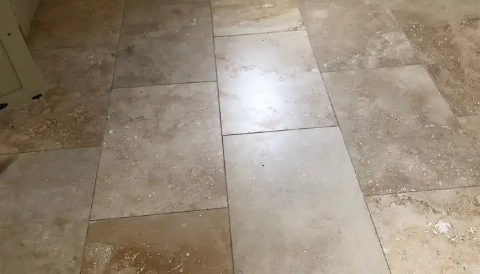 Close-up view of travertine floor showcasing pits, open holes, and filler repairs
