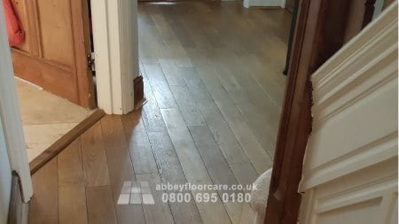 Worn terrazzo floor with dull surface and visible scuff marks before restoration
