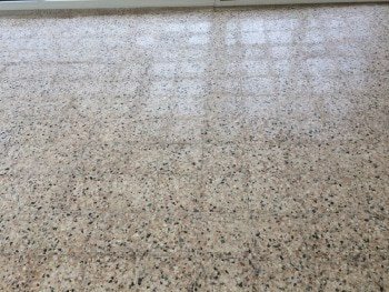 Indoor terrazzo floor showing dullness and surface wear before restoration