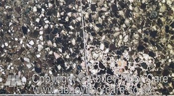 Close-up of weathered outdoor terrazzo patio surface before restoration